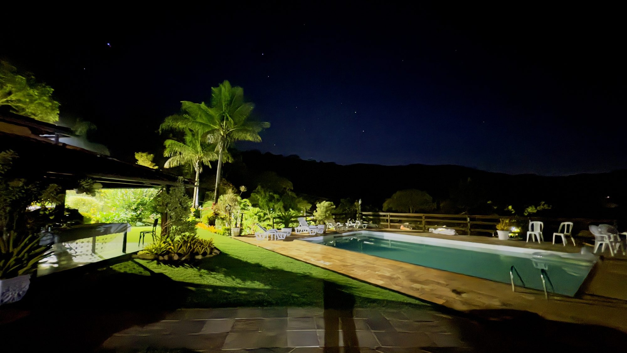 Piscina e jardim iluminados durante a noite